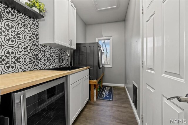 1909 Shepard Rd, Wildwood, MO 63038 - washroom featuring wine cooler, baseboards, and dark wood-style flooring