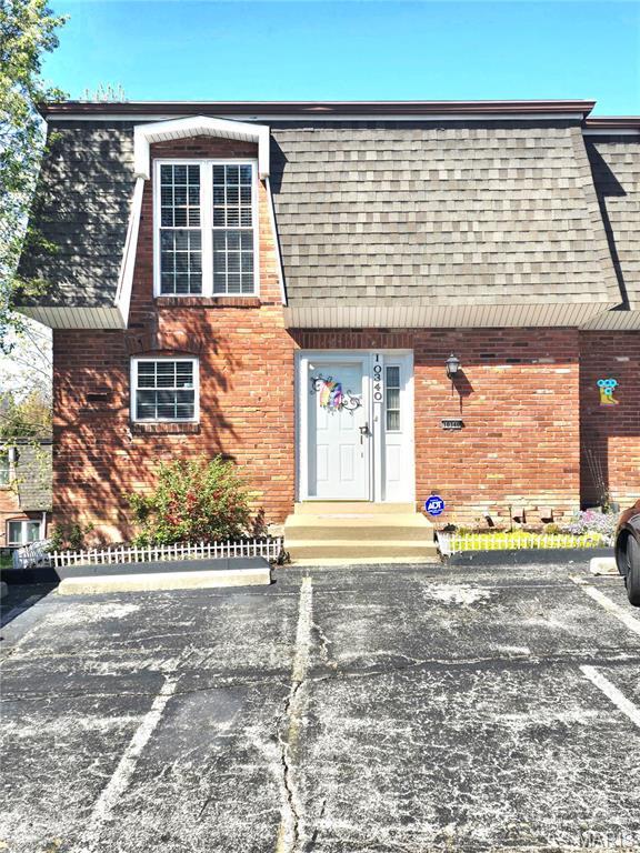 10340 Corbeil Dr, Saint Louis, MO 63146 - view of front facade with uncovered parking, roof with shingles, brick siding, and mansard roof