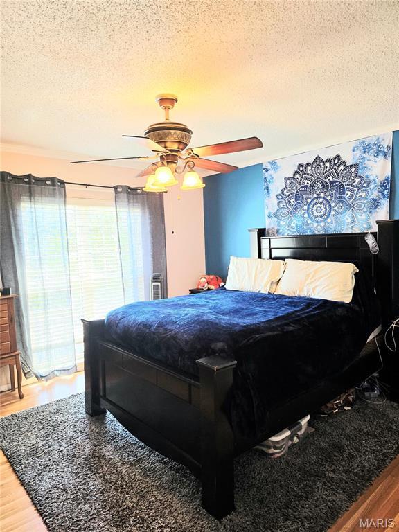 10340 Corbeil Dr, Saint Louis, MO 63146 - bedroom with a textured ceiling, wood finished floors, and a ceiling fan
