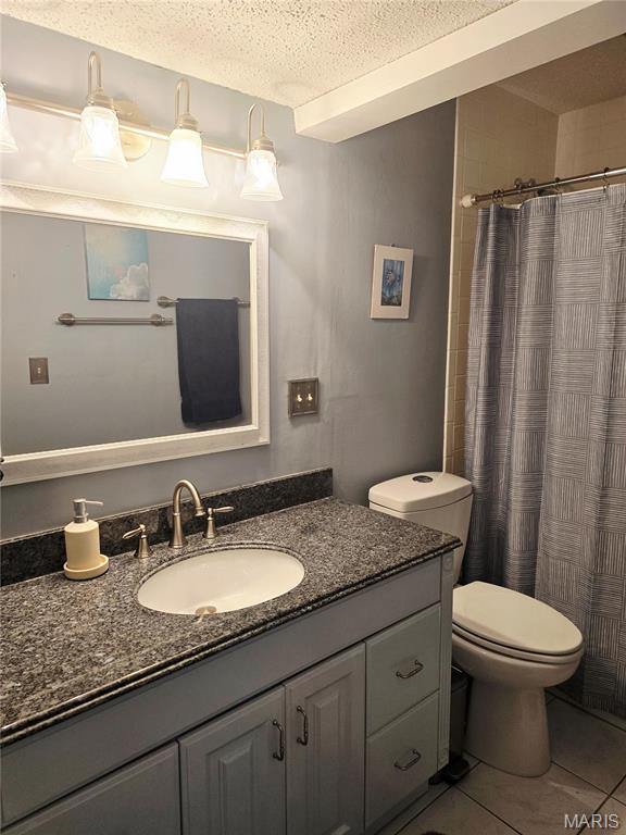 10340 Corbeil Dr, Saint Louis, MO 63146 - bathroom with vanity, toilet, tile patterned floors, a textured ceiling, and curtained shower