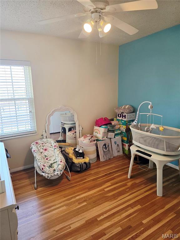 10340 Corbeil Dr, Saint Louis, MO 63146 - rec room featuring wood finished floors, a textured ceiling, and a ceiling fan