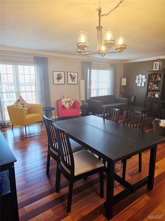 10340 Corbeil Dr, Saint Louis, MO 63146 - dining area with a chandelier, crown molding, a textured ceiling, and wood finished floors