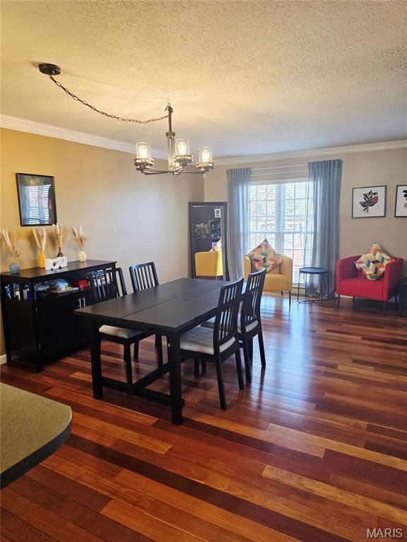 10340 Corbeil Dr, Saint Louis, MO 63146 - dining space with a chandelier, a textured ceiling, ornamental molding, and wood finished floors