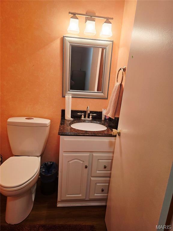 10340 Corbeil Dr, Saint Louis, MO 63146 - half bath featuring vanity, toilet, and wood finished floors