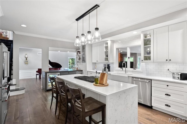 13552 Weston Park Dr, Saint Louis, MO 63131 - kitchen featuring dishwasher, a center island, crown molding, a kitchen breakfast bar, and glass insert cabinets