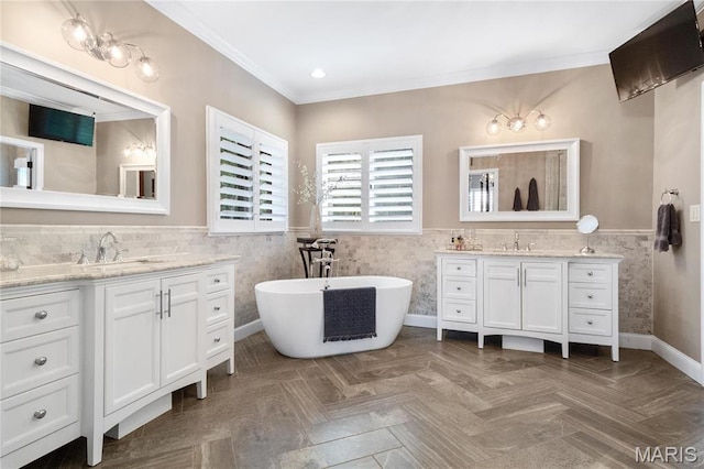 13552 Weston Park Dr, Saint Louis, MO 63131 - full bathroom featuring tile walls, wainscoting, two vanities, a freestanding tub, and crown molding