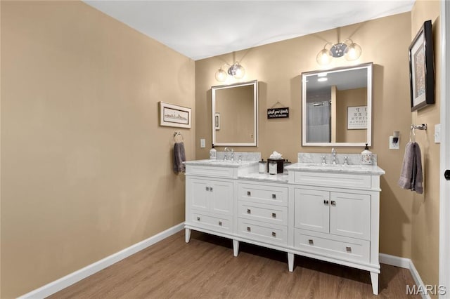 13552 Weston Park Dr, Saint Louis, MO 63131 - bathroom featuring wood finished floors, baseboards, double vanity, and a shower