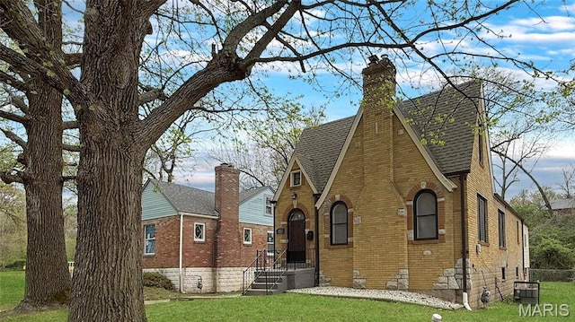 4411 Nelson Dr, Saint Louis, MO 63121 - rear view of property with roof with shingles, a yard, brick siding, and a chimney