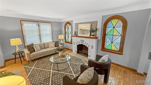 4411 Nelson Dr, Saint Louis, MO 63121 - living area featuring baseboards, wood finished floors, and a brick fireplace