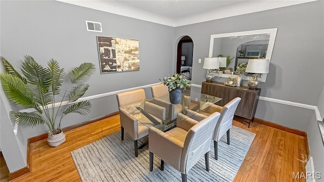 4411 Nelson Dr, Saint Louis, MO 63121 - dining room with arched walkways, light wood-style floors, and baseboards