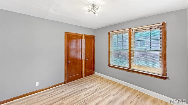 4411 Nelson Dr, Saint Louis, MO 63121 - unfurnished bedroom with baseboards, light wood-style floors, and a closet