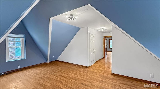 4411 Nelson Dr, Saint Louis, MO 63121 - additional living space featuring wood finished floors, plenty of natural light, and vaulted ceiling