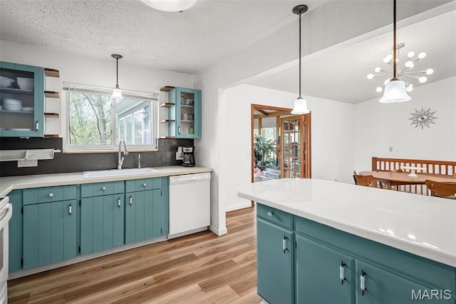 kitchen featuring dishwasher, open shelves, a sink, a textured ceiling, and light wood-style flooring