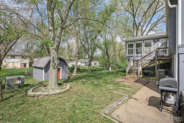 view of green lawn featuring stairs, a sunroom, a storage unit, and an outdoor structure