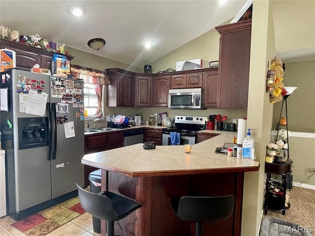 22880 Return Ln, Waynesville, MO 65583 - kitchen featuring appliances with stainless steel finishes, a peninsula, light countertops, a breakfast bar area, and a sink