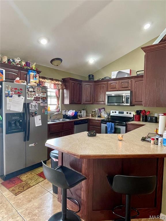 22880 Return Ln, Waynesville, MO 65583 - kitchen with stainless steel appliances, light countertops, a peninsula, a breakfast bar, and a sink