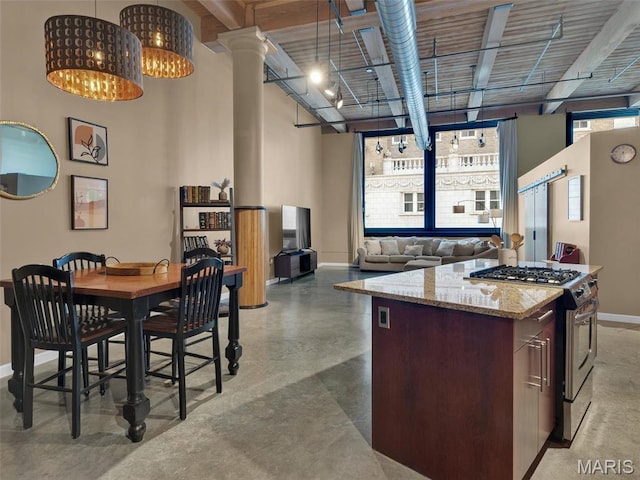 901 Washington Ave Unit 205, Saint Louis, MO 63101 - kitchen featuring stainless steel range with gas cooktop, baseboards, decorative columns, a center island, and light stone counters