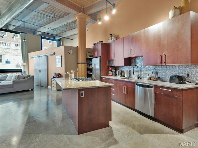 901 Washington Ave Unit 205, Saint Louis, MO 63101 - kitchen with stainless steel appliances, a sink, decorative backsplash, a towering ceiling, and a center island