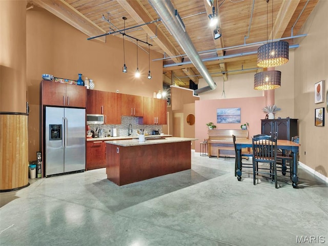 901 Washington Ave Unit 205, Saint Louis, MO 63101 - kitchen with stainless steel appliances, a towering ceiling, light countertops, concrete floors, and brown cabinets
