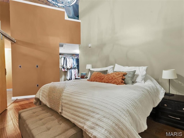 901 Washington Ave Unit 205, Saint Louis, MO 63101 - bedroom with wood finished floors, a barn door, and baseboards