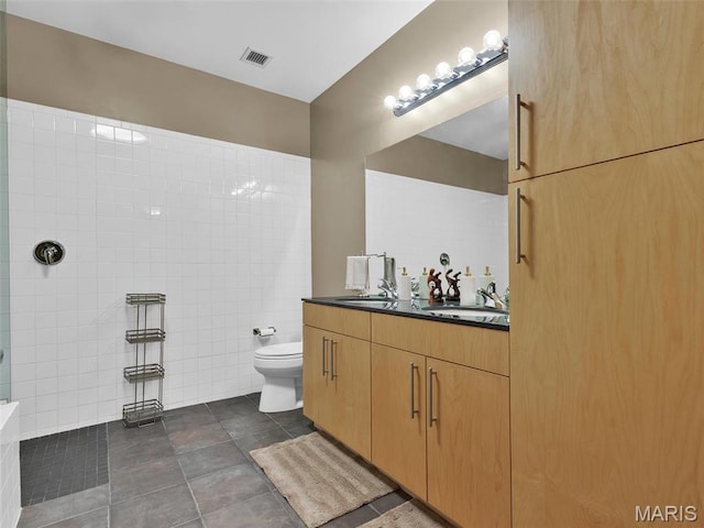 901 Washington Ave Unit 205, Saint Louis, MO 63101 - full bathroom with tile walls, toilet, a walk in shower, vanity, and tile patterned flooring