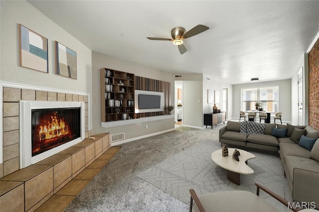 carpeted living room with a ceiling fan and a fireplace