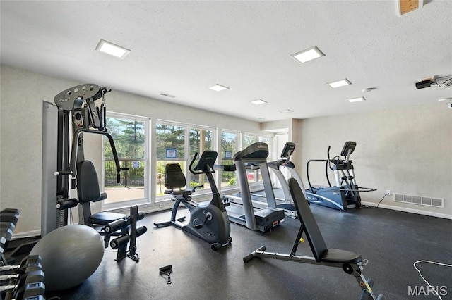 workout area featuring baseboards and a textured ceiling