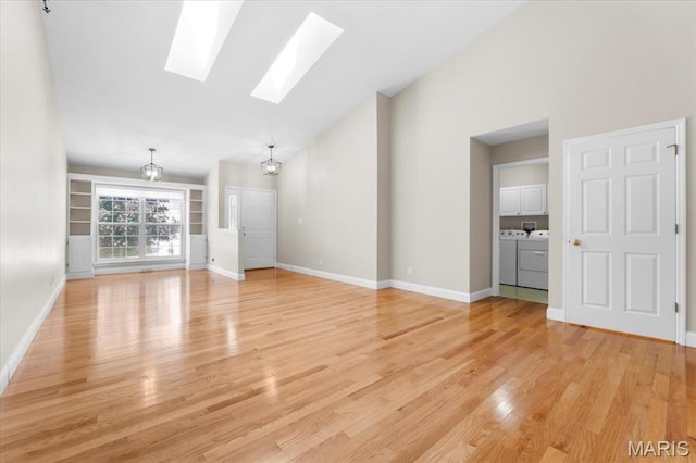 1136 Arbor Place Dr, Manchester, MO 63088 - unfurnished living room featuring washing machine and clothes dryer, a skylight, light wood-type flooring, and high vaulted ceiling