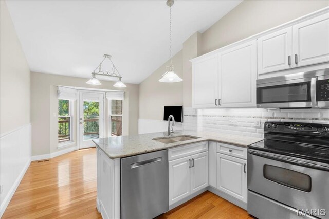 1136 Arbor Place Dr, Manchester, MO 63088 - kitchen with appliances with stainless steel finishes, decorative backsplash, white cabinets, lofted ceiling, and light wood-style floors