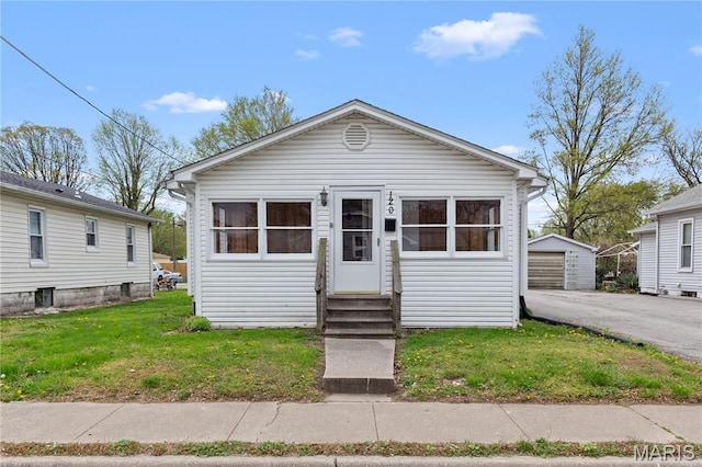 120 E 1st St, Hartford, IL 62048 - shotgun-style home featuring entry steps, a detached garage, a front yard, and an outdoor structure