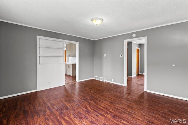 120 E 1st St, Hartford, IL 62048 - empty room with a textured ceiling, dark wood finished floors, ornamental molding, and baseboards
