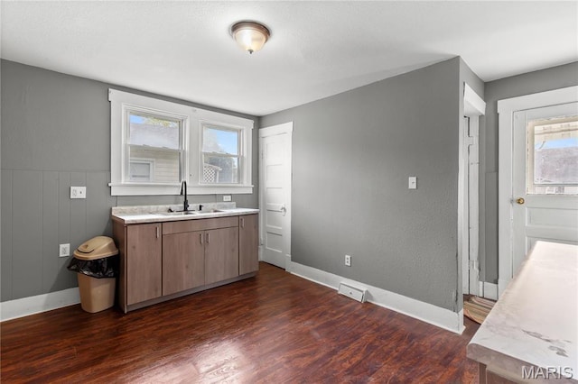 120 E 1st St, Hartford, IL 62048 - kitchen featuring a sink, dark wood-style flooring, light countertops, and baseboards