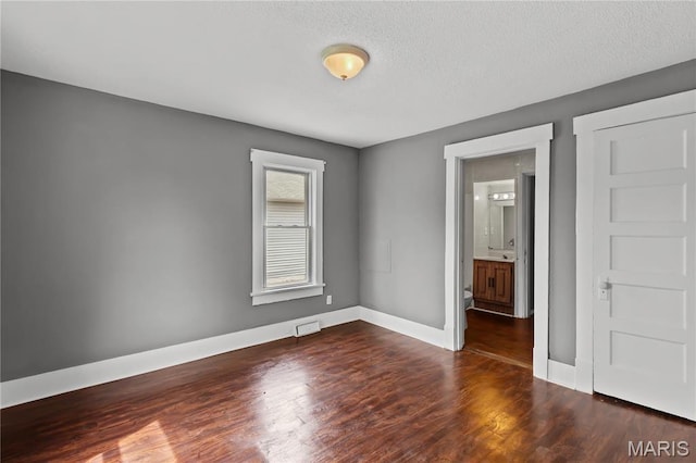 120 E 1st St, Hartford, IL 62048 - spare room featuring dark wood-type flooring and baseboards