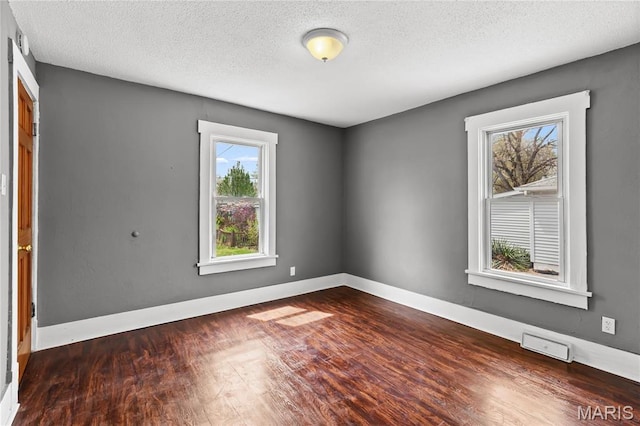 120 E 1st St, Hartford, IL 62048 - empty room featuring wood finished floors, a textured ceiling, and baseboards