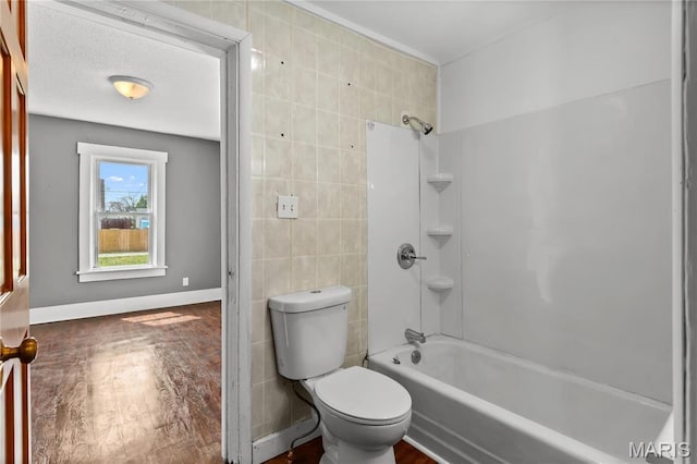 120 E 1st St, Hartford, IL 62048 - bathroom featuring wood finished floors, tile walls, toilet, shower / tub combination, and baseboards