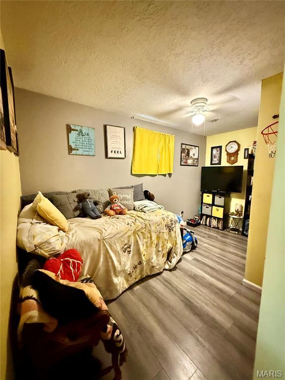 42 Berger Rd, Middletown, MO 63359 - bedroom with wood finished floors, a textured ceiling, and ceiling fan