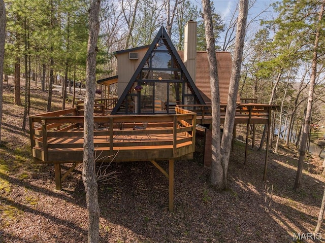 rear view of property with a deck and a chimney