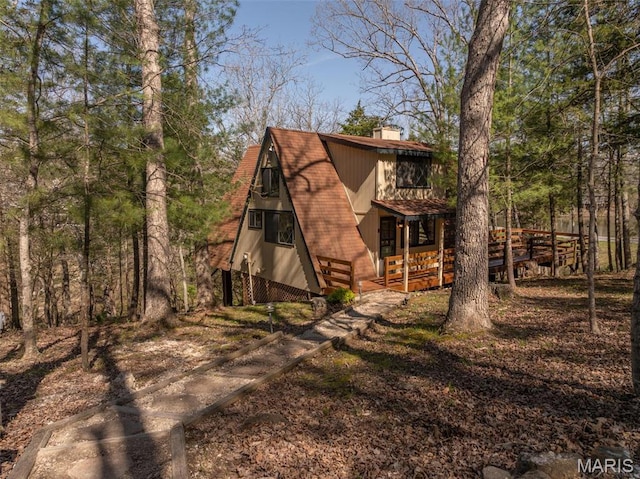 view of front of house featuring a chimney and a porch