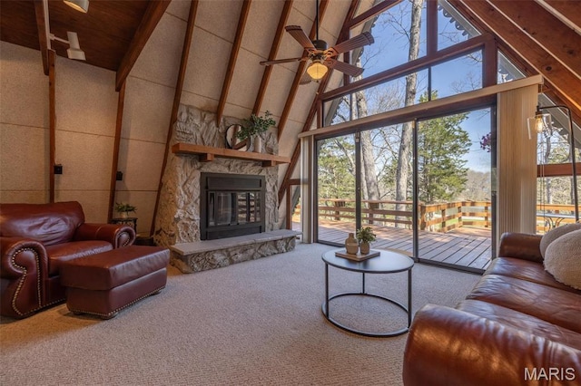 carpeted living room with high vaulted ceiling, a ceiling fan, beam ceiling, and a stone fireplace