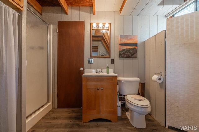 full bathroom with wood finished floors, a stall shower, vanity, beamed ceiling, and toilet