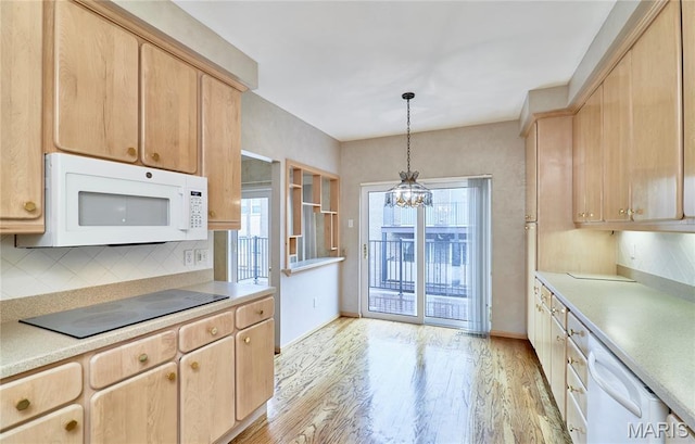 10359 Corbeil Dr Unit D, Saint Louis, MO 63146 - kitchen with white appliances, a chandelier, light brown cabinets, light wood-style flooring, and tasteful backsplash