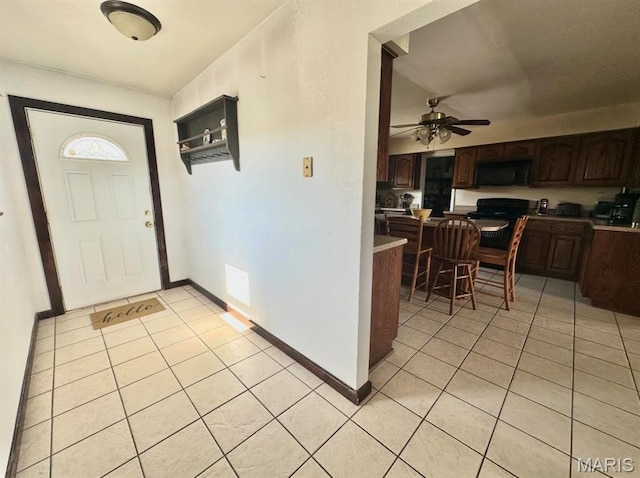 foyer entrance featuring light tile patterned floors, a ceiling fan, and baseboards