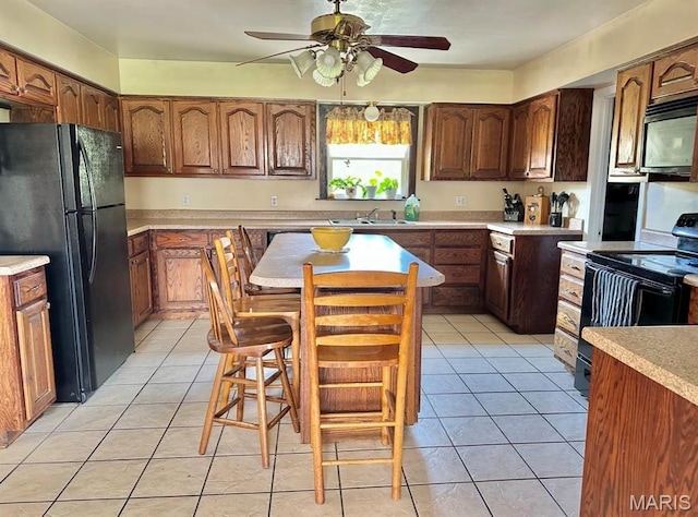 kitchen with black appliances, a ceiling fan, a sink, and light countertops
