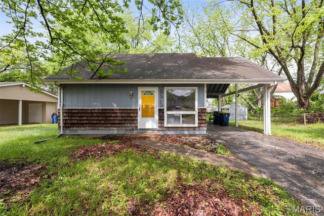 2797 Dawnview Dr, Florissant, MO 63031 - view of front of house with an outdoor structure, asphalt driveway, roof with shingles, a carport, and entry steps