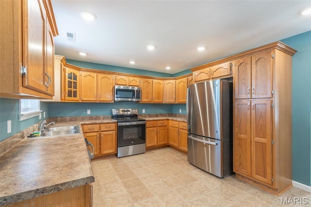 1501 Vincent St, Poplar Bluff, MO 63901 - kitchen featuring stainless steel appliances, a sink, brown cabinetry, recessed lighting, and glass insert cabinets