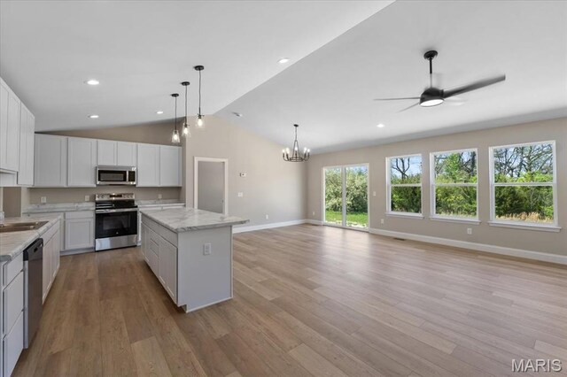 1423 Wild Ridge Estates Ct, Florissant, MO 63033 - kitchen with stainless steel appliances, baseboards, a chandelier, a kitchen island, and vaulted ceiling