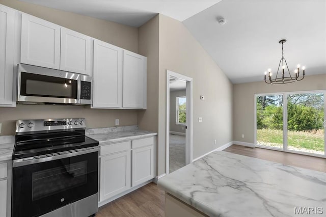 1423 Wild Ridge Estates Ct, Florissant, MO 63033 - kitchen featuring stainless steel appliances, lofted ceiling, a chandelier, light wood-style floors, and healthy amount of natural light