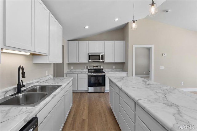 1423 Wild Ridge Estates Ct, Florissant, MO 63033 - kitchen featuring stainless steel appliances, a sink, vaulted ceiling, white cabinetry, and pendant lighting