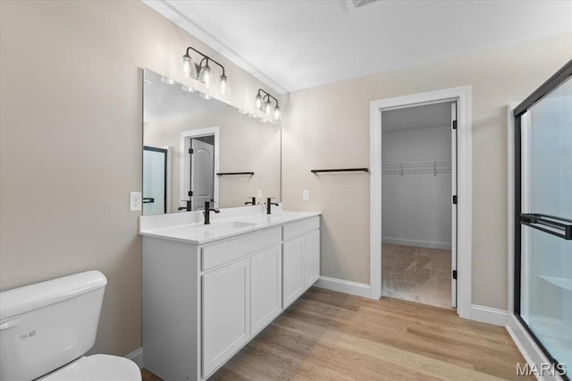 1423 Wild Ridge Estates Ct, Florissant, MO 63033 - full bath with toilet, a shower stall, wood finished floors, double vanity, and a walk in closet