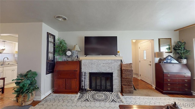 living area featuring a fireplace, baseboards, and light wood-style floors